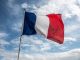 French Flag Waving Against Blue Cloudy Sky