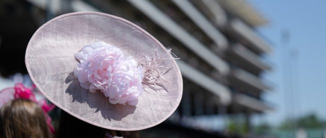 Lady with Pink Hat Against Racecourse Grandstand